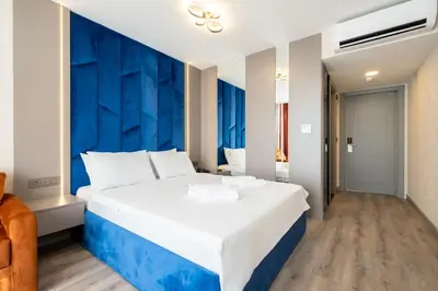a large white bed in a room with a blue wall at The Port Güzelyalı in Pendik