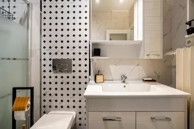 a white bathroom with a sink and a shower at sevim suites Nişantaşı Center in Istanbul