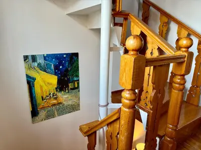 a painting hanging on a wall next to a staircase at The Wooden 17 in Istanbul