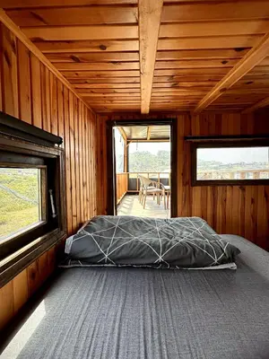 a bedroom with a bed in a wooden cabin at Kackar Kamp istanbul in Domalı