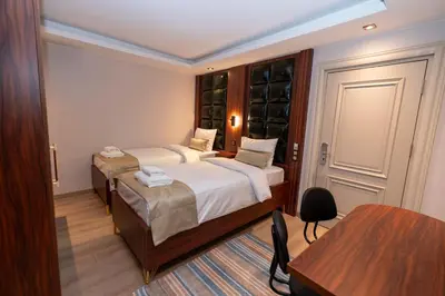 a small bedroom with two beds and a table at THE MUA LUXURY HOMEs in Istanbul