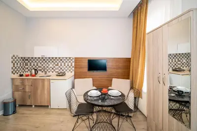 a dining room with a table and chairs and a kitchen at New Life Taksim Apart Hotel in Istanbul