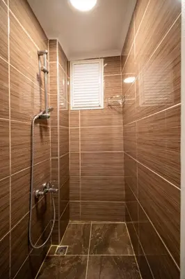 a bathroom with a shower with wooden walls at New Life Taksim Apart Hotel in Istanbul