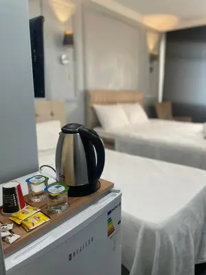a tea kettle on a counter in a room with beds at Kıyı Butik Otel in Mimarsinan