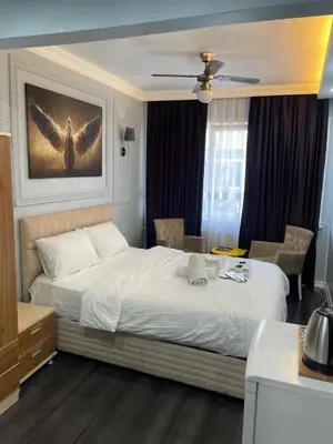 a bedroom with a large bed with an angel painting on the wall at Kıyı Butik Otel in Mimarsinan