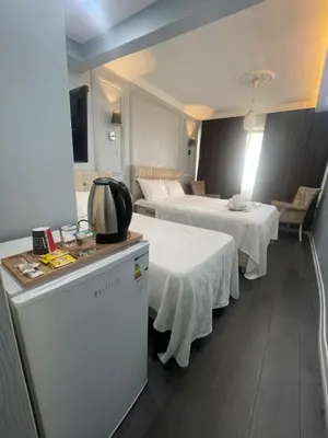 a hotel room with two beds with white tables at Kıyı Butik Otel in Mimarsinan