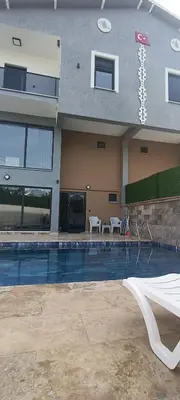 a building with a swimming pool in front of it at Naturel villaları in Orhangazi