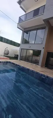 a house with a swimming pool in front of a house at Naturel villaları in Orhangazi