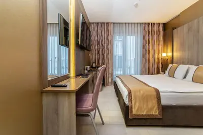 a hotel room with a bed and a desk with a mirror at Royal Capital Hotel Bursa in Bursa
