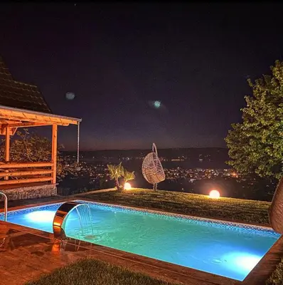 a swimming pool at night with a view of a city at papatya in Sapanca