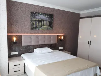a bedroom with a bed and a painting on the wall at Asım ve nurhan kocabıyık öğretmenevi in Avcılar