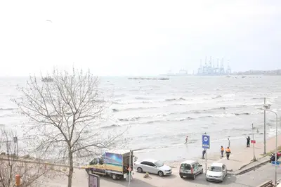 a group of cars parked on a beach next to the water at Asım ve nurhan kocabıyık öğretmenevi in Avcılar