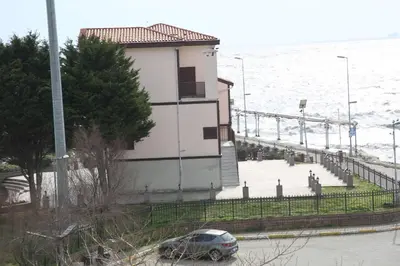 a car parked in front of a building next to the water at Asım ve nurhan kocabıyık öğretmenevi in Avcılar