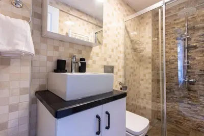 a bathroom with a white sink and a shower at Pretty Corner Flat with Abundant Light in Kadikoy in Istanbul