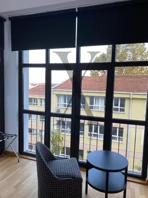 a room with a large window with a table and chairs at X Flats Kaiser in Istanbul