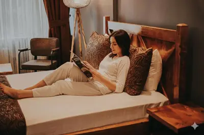 a woman sitting on a bed reading a book at Zengin City Hotel in Istanbul