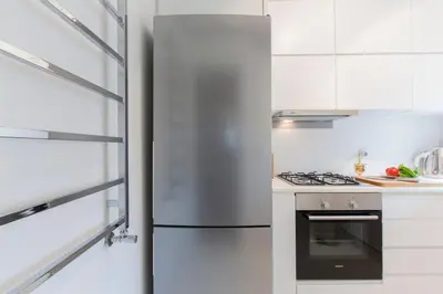 a white kitchen with a refrigerator and a stove at Architect Jonas generous 85 sqm apartment full of Art in Istanbul