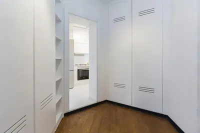 a white kitchen with white cabinets and a wooden floor at Architect Jonas generous 85 sqm apartment full of Art in Istanbul