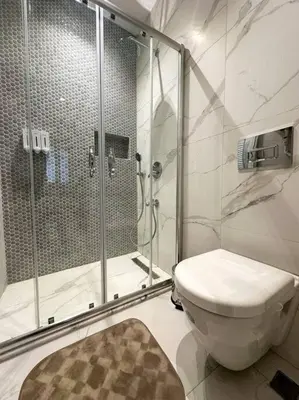 a bathroom with a shower and a toilet with a glass shower backdoor at ŞAHİN PERA SUİT2 Great location 2 Br air-conditioned apartment in Istanbul