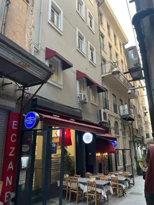 a restaurant with tables and chairs in front of a building at ŞAHİN PERA SUİT2 Great location 2 Br air-conditioned apartment in Istanbul