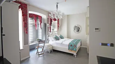 a bedroom with a white bed and a chandelier at Excellent Apartments Galata in Istanbul