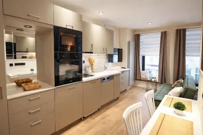 a kitchen with white cabinets and a living room at Excellent Apartments Galata in Istanbul