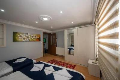 a bedroom with two beds and a painting on the wall at TAKSIM SUITE Apartment in Istanbul