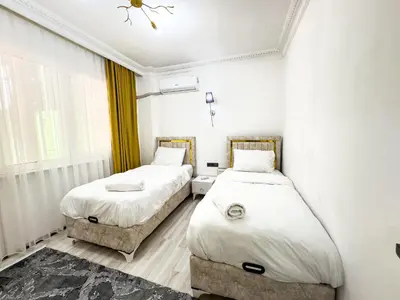 two beds in a room with white walls at Sisli Apartments Holiday231 in Istanbul