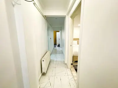 a hallway with white walls and a white floor at Sisli Apartments Holiday231 in Istanbul