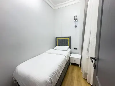 a small bedroom with a white bed and a window at Sisli Apartments Holiday441 in Istanbul