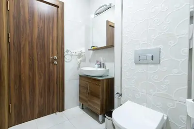 a white bathroom with a sink and a toilet at Beyzas Hotels & Suites in Istanbul