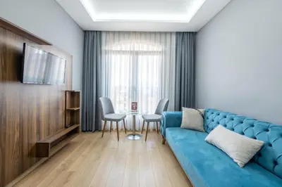 a living room with a blue couch and a table at Beyzas Hotels & Suites in Istanbul