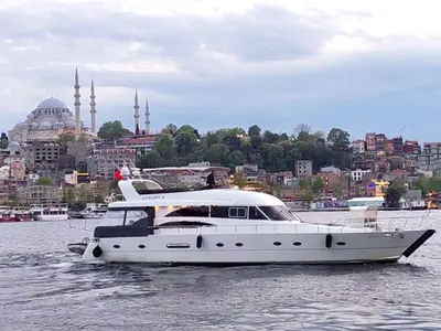 a white boat in the water with a city in the background at Luxury Yachts Istanbul in Istanbul