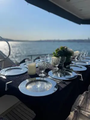 a long table with plates and wine glasses on a boat at Luxury Yachts Istanbul in Istanbul