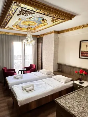 a hotel room with two beds and a chandelier at taksim white family suites in Istanbul