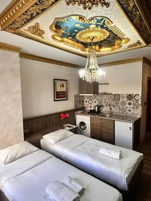two beds in a room with a chandelier at taksim white family suites in Istanbul