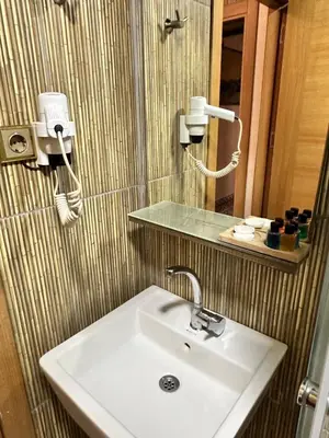 a bathroom with a white sink and a mirror at taksim white family suites in Istanbul