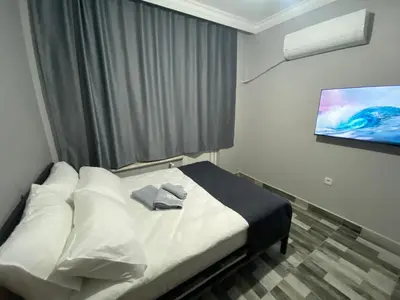 a bedroom with a bed with a tv on the wall at Pamir Butik Otel in Bursa