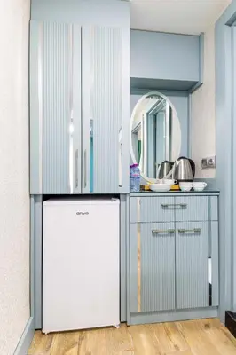 a kitchen with a white refrigerator and a mirror at Santa Rio Gold Taxim Hotel in Istanbul