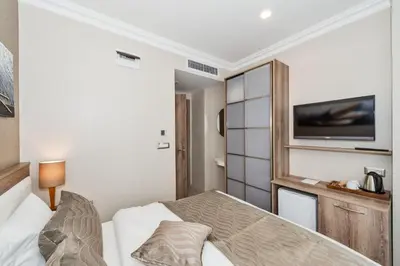 a bedroom with a bed and a tv on the wall at Alphonse Hotel in Istanbul