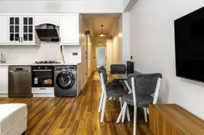 a kitchen with a table and chairs in a room at NIŞANTAŞI JANTY LUXURY, 4 NEW APARTMENTs in Istanbul