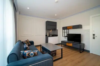 a living room with a blue couch and a tv at Rusel Park Residence in Bahcesehir