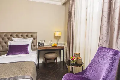 a hotel room with a bed and a desk at Meroddi Bağdatlıyan - 1892 Heritage Rooms by Galata Tower in Istanbul