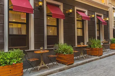 a row of tables and chairs in front of a building at Meroddi Bağdatlıyan - 1892 Heritage Rooms by Galata Tower in Istanbul