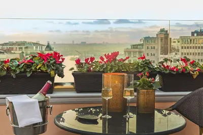 a table with wine glasses and a window with flowers at Meroddi Bağdatlıyan - 1892 Heritage Rooms by Galata Tower in Istanbul