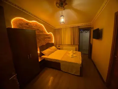 a bedroom with a bed with a light on the wall at Ulusoy Cafe in Istanbul