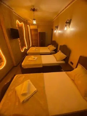a hotel room with three beds in a room at Ulusoy Cafe in Istanbul