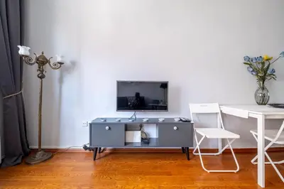 a living room with a tv and a table and a chair at Spacious Dublex in Cihangir in Istanbul