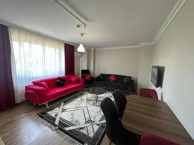 a living room with a red couch and a table at Şişli mado 9 2 3 in Istanbul