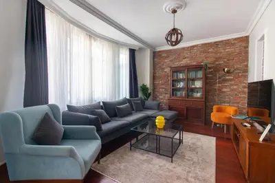 a living room with a blue couch and a brick wall at Tasteful & Spacious 3BR Haven in Trendy Şişli in Istanbul